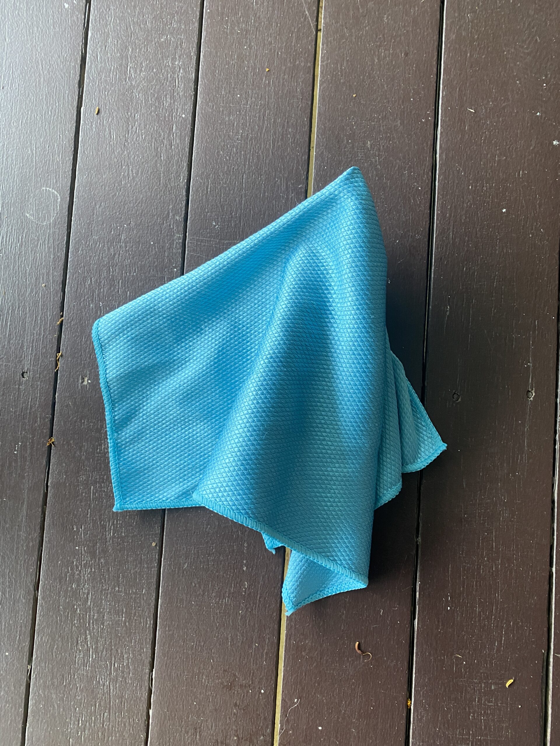 Microfiber cloth wiping the edges and catching drips after squeegeeing